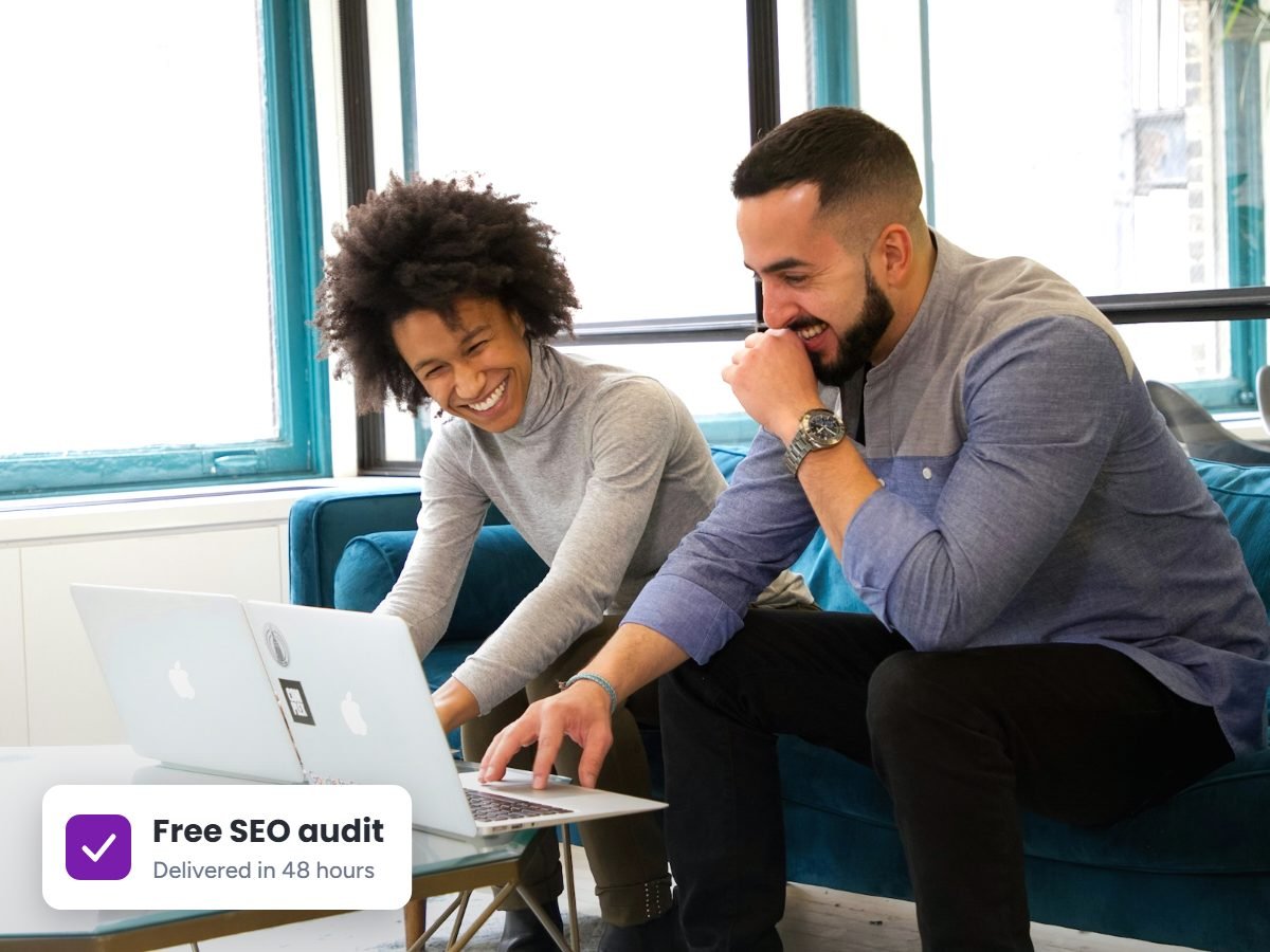 Business owner and SEO consultant going over a free SEO audit on a laptop