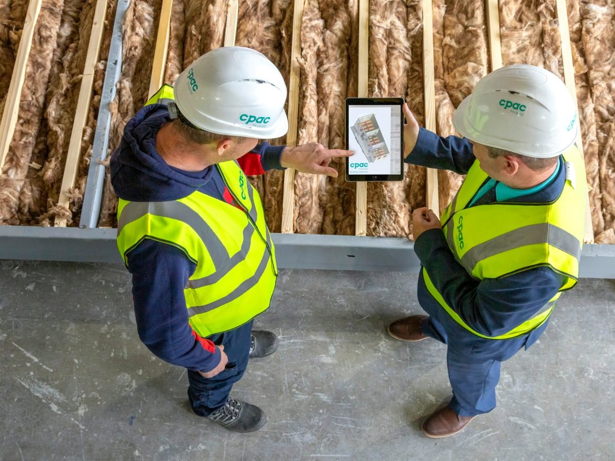 Contractors reviewing plans on a tablet at a job site