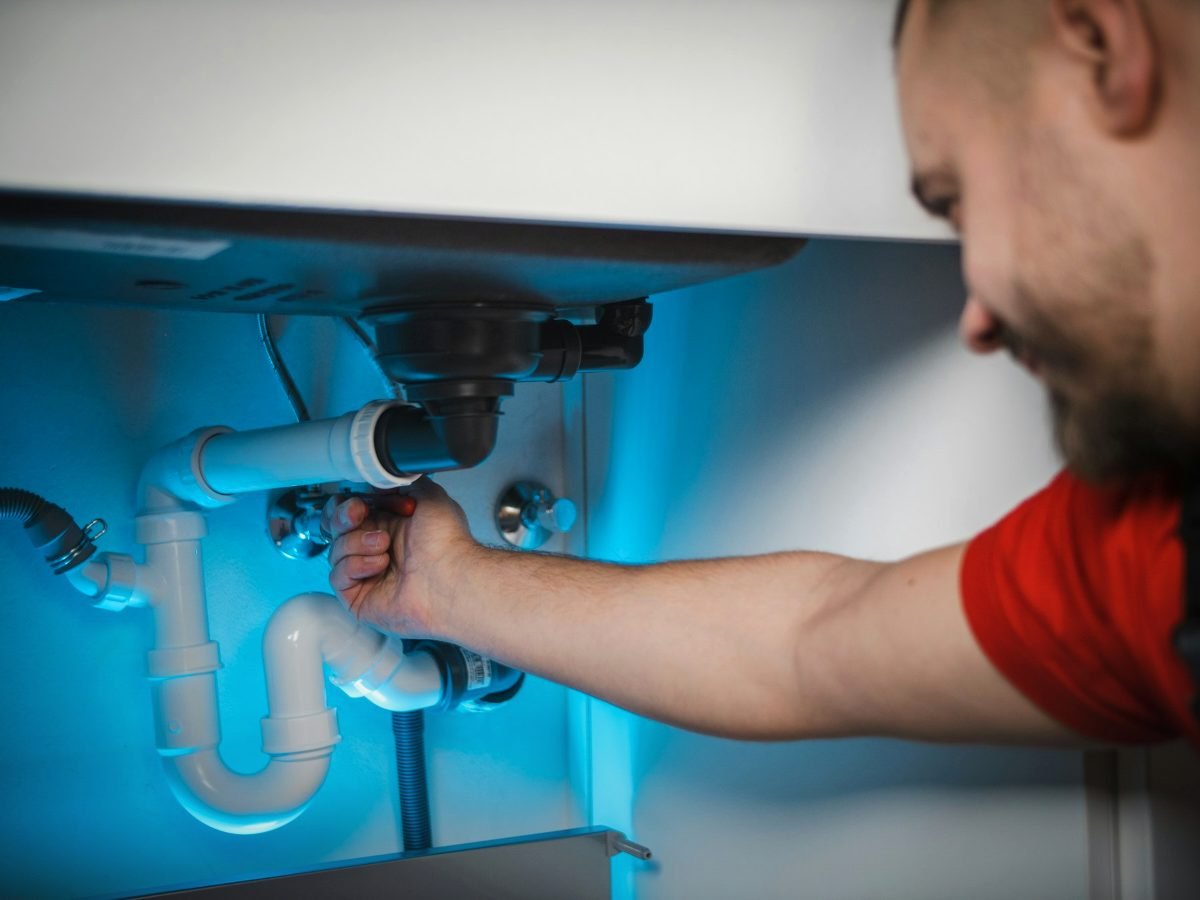 Plumber repairing a sink pipe, representing SEO for home service businesses