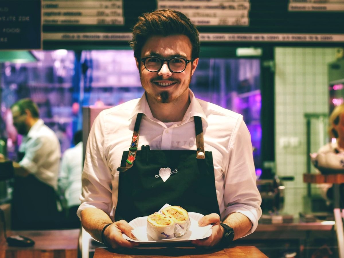 Restaurant owner serving food, representing local SEO for restaurants