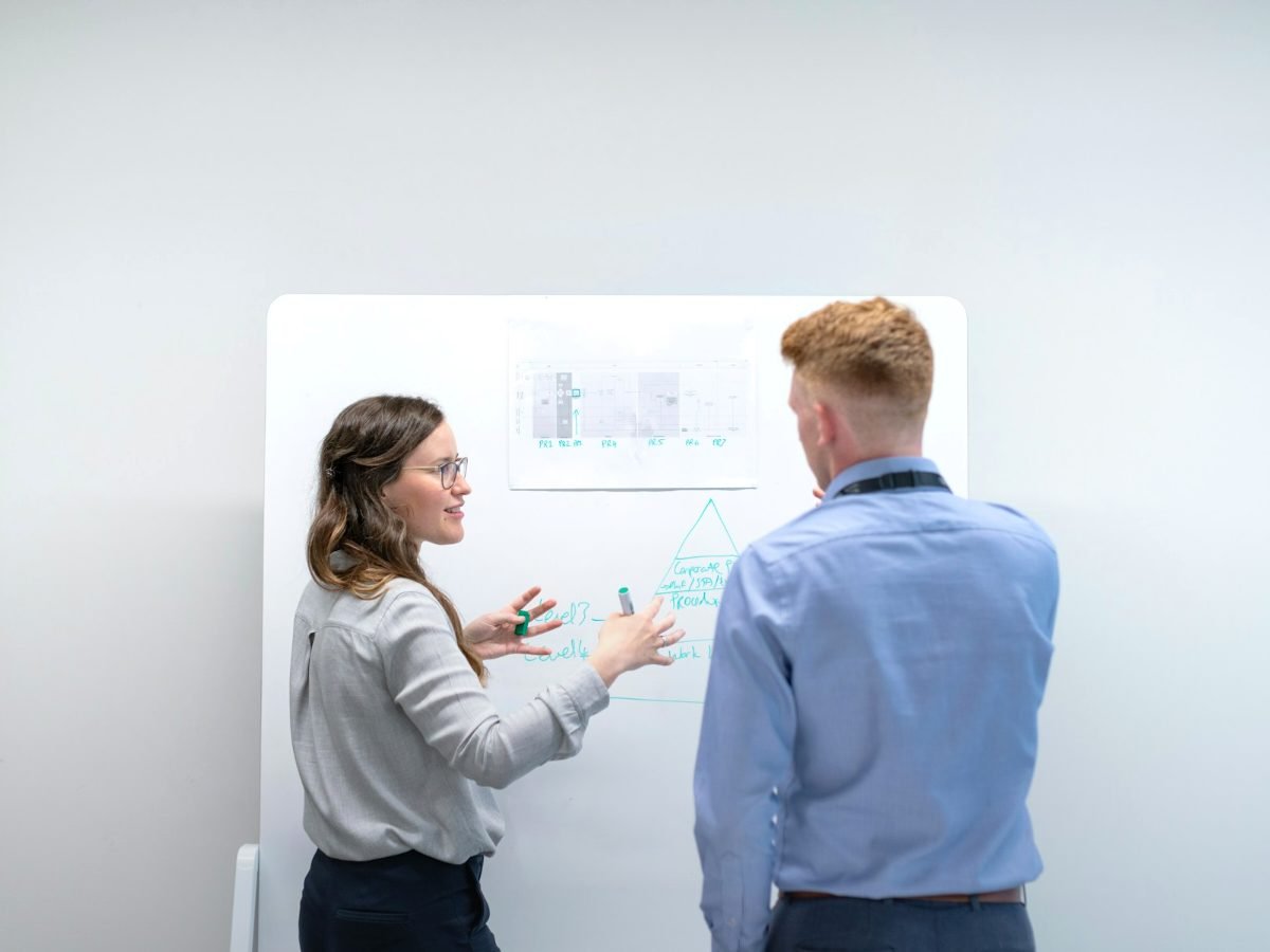Two SEO strategists planning a link building campaign on a whiteboard