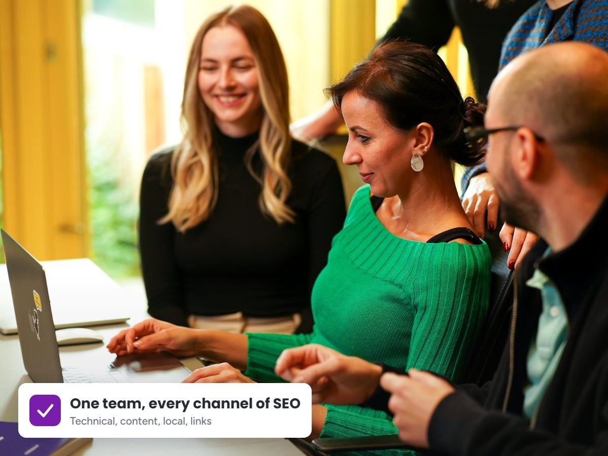 SEO team collaborating around a laptop on a client strategy